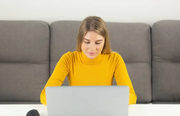 漂亮的金发白人女人关在家里的笔记本电脑上有魅力的年轻成年女性在笔记本电脑上打字 在网上做远程工作的女企业家 — 图库照片