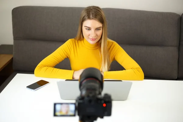 博客女性在摄像机前聊天 漂亮的金发女孩在家里拍摄视频博客镜头 在网上从事远程工作的创业者 — 图库照片