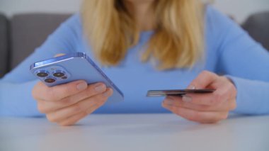 İnternetten alışveriş yapan ve kredi kartıyla ödeyen bir kadın. Modern akıllı telefon aygıtı ve banka kartı ile internet mağazasında puchase yapan müşterilerin elleri