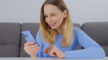 Mutlu beyaz kadın cep telefonundan internet haberlerine bakıyor. 40 'lı yaşlarda güzel bir bayan eğlence ve iletişim için modern akıllı telefon kullanıyor. Neşeli kişi sosyal medya uygulaması getirdi