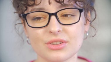 Güzel beyaz kadın web kamerasından konuşuyor. İnek gözlüklü tatlı esmer kadın video görüşmesi sırasında laptop kamerasından konuşuyor. Çevrimiçi ağ kuran genç ve güzel insanlar.