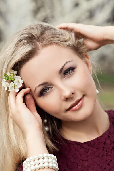 Krásná blonďatá dívka v jarní zahradě — Stock fotografie