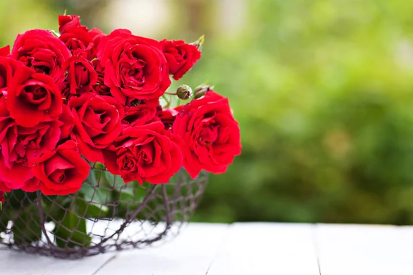 Buquê de rosas vermelhas na cesta ao ar livre — Fotografia de Stock