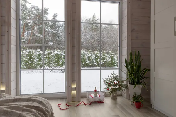 Скандинавська вітальня в дерев'яному будинку. Різдвяний прикрас, ялинка і подарунок, велике вікно. — стокове фото