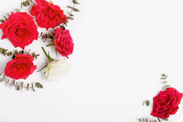 Composición de flores. Marco hecho de flores de rosa roja sobre fondo blanco. Plano, vista superior, espacio para copiar —  Fotos de Stock