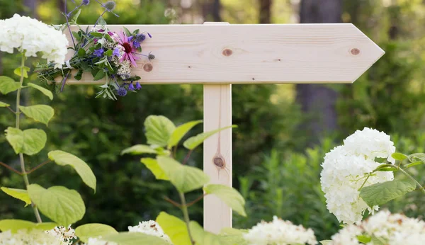 Cerimônia de casamento sinal de madeira com um buquê de flores silvestres em um fundo de hortênsias brancas — Fotografia de Stock