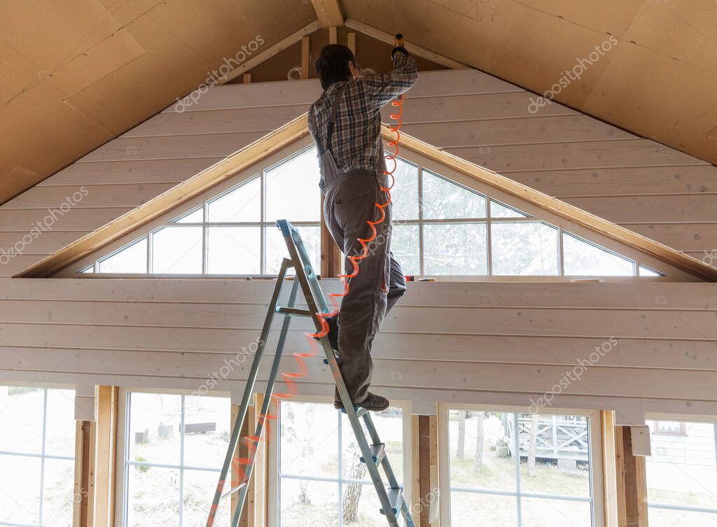 Construction worker thermally insulating eco wooden frame house