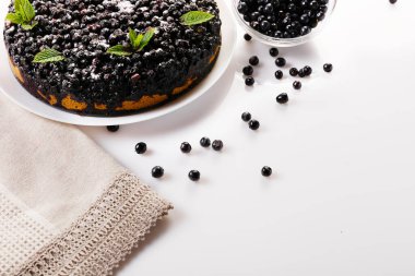 Beyaz arkaplanda beyaz bir tabakta naneli yaban mersinli turta, üst görünüm yatay yakın plan, metin için boşluk