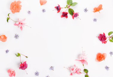 Flat lay festive frame with pink, orange, purple flower buds, branches and leaves on white background, top view