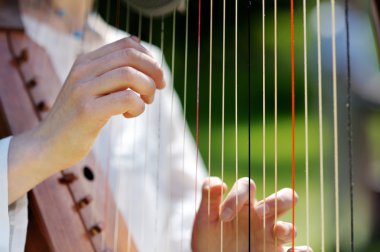 Closeup of a Woman playing a Harp clipart