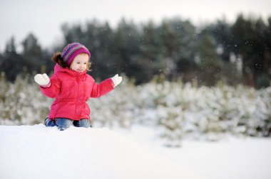 Küçük kız kışın eğleniyor.