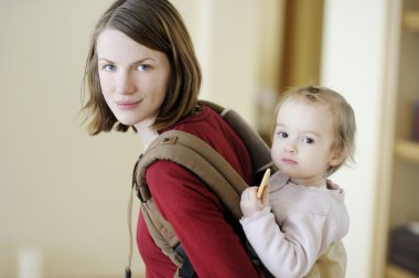 genç anne ve kızı içinde bebek taşıyıcı