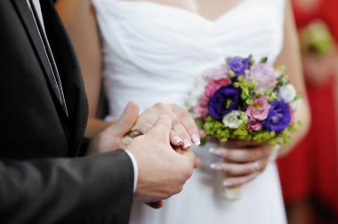 Damat gelinin elini tutuyor.