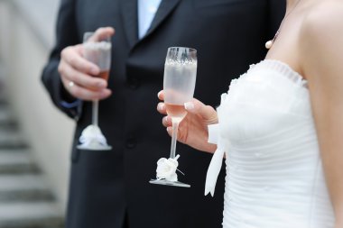 Gelin ve damat şampanya bardağı tutan