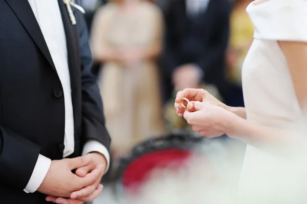 Невеста надевает кольцо на палец жениха — стоковое фото