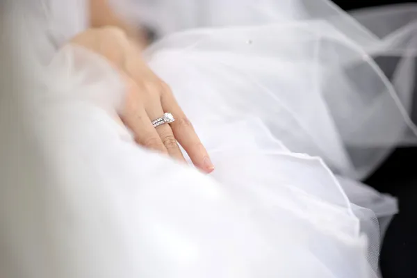 Bruidskamer hand opleggen van een trouwjurk — Stockfoto