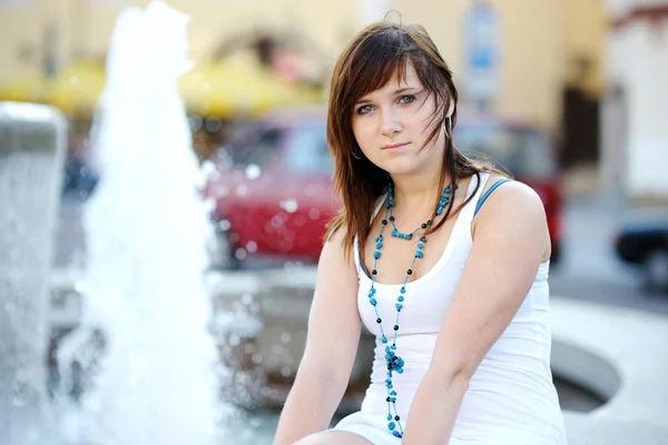 Young attractive woman by a fountain — Stock Photo, Image