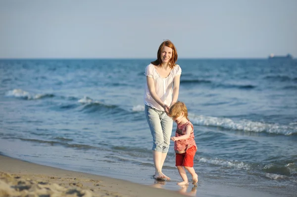 Mãe feliz com sua filha em uma praia — Fotografia de Stock