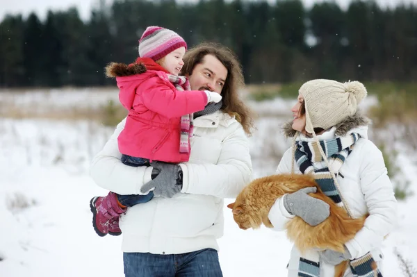 Familia feliz y un gato en un día de invierno — Foto de Stock