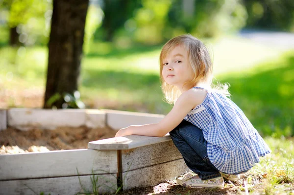 Маленькая девочка играет в песочнице — стоковое фото