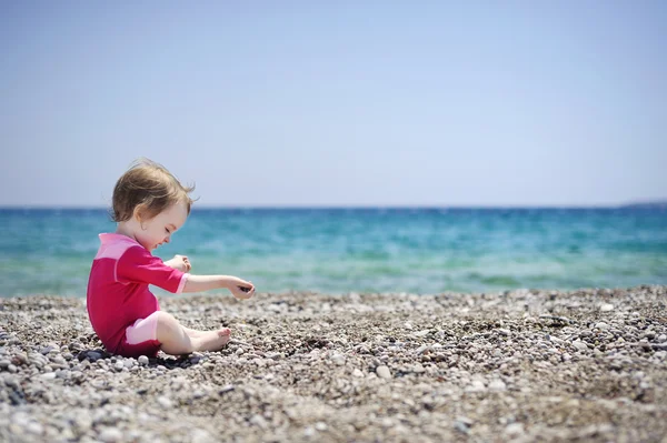 Ładny dziewczyna gra na kamienistej plaży — Zdjęcie stockowe