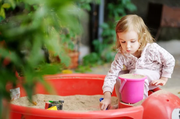 Little girl playing in a sandbox — Stock Photo, Image