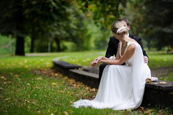 Novia y novio están sentados en el parque de otoño — Foto de Stock