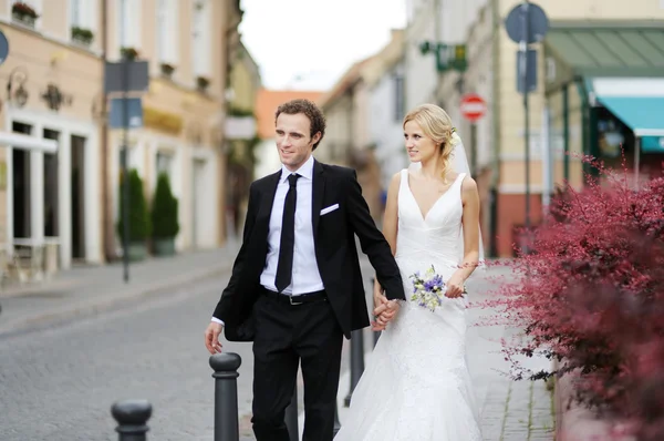 Bride and groom walking in a town — Stock Photo, Image