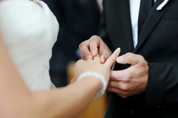 Groom putting a ring on bride's finger — Stock Photo, Image