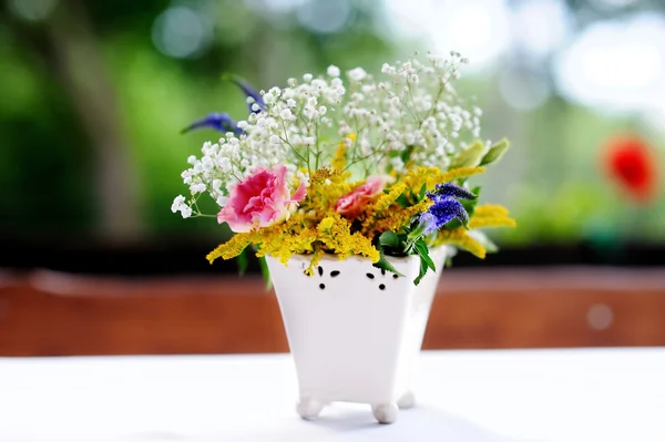 Um vaso cheio de flores variadas — Fotografia de Stock