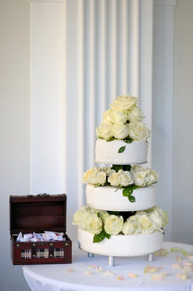 Grande torta nuziale e una scatola piena di dolci — Foto Stock