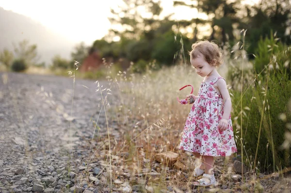 Roztomilé batole dívka v květovaných šatech — Stock fotografie