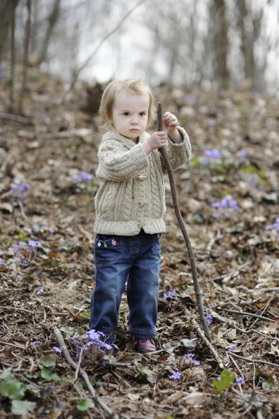 Lilla barn flicka som leker med en pinne — Stockfoto