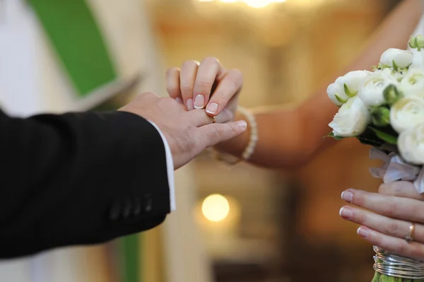 Novia poniendo un anillo en el dedo del novio — Foto de Stock