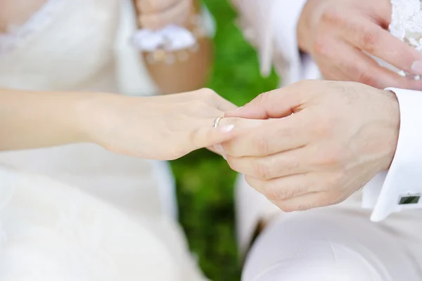 Novio poniendo un anillo en el dedo de la novia — Foto de Stock