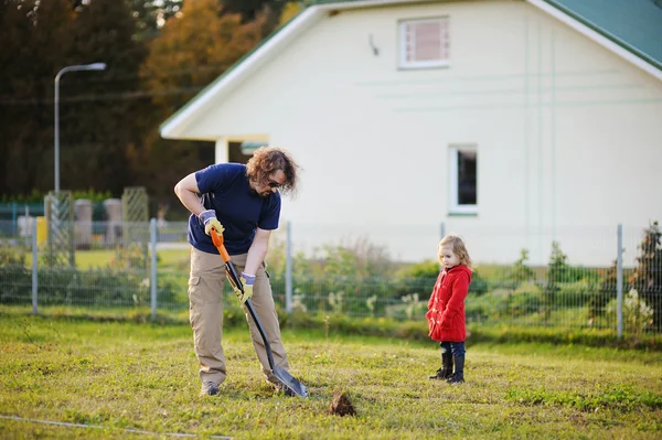 A man shovels a hole in the yard — Stock Photo, Image