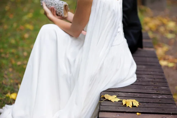 Bride sitting in autumn park — Stock Photo, Image