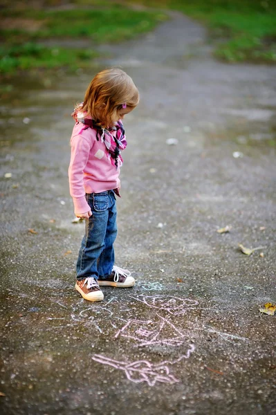 Petite fille regardant un dessin à la craie — Photo