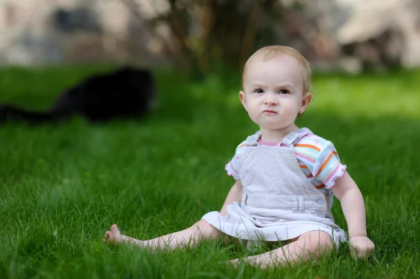 幼児の女の子と、バック グラウンドで猫 — ストック写真