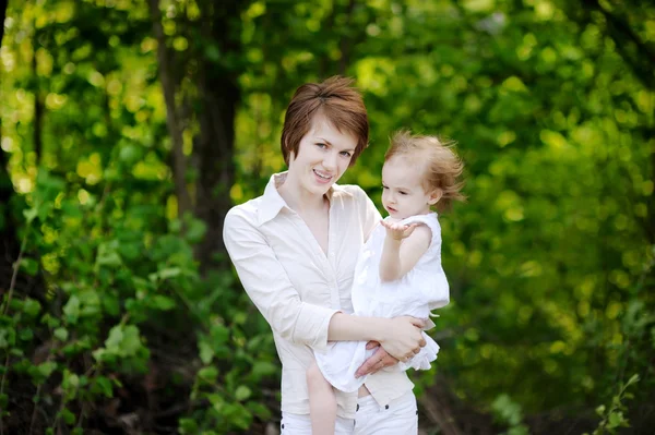 Jonge moeder houden haar schattig meisje — Stockfoto