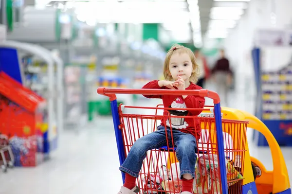 Niño adorable sentado en el carrito de la compra — Foto de Stock
