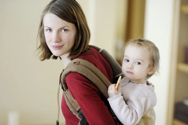 Genç anne ve kızı içinde bebek taşıyıcı — Stok fotoğraf