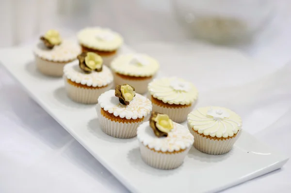 Magdalenas de crema de vainilla blanca en un plato blanco —  Fotos de Stock