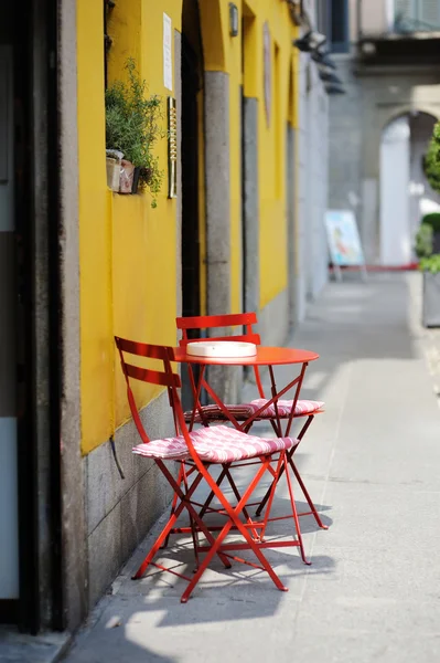 Piros székek, egy sárga festett fal ellen — Stock Fotó