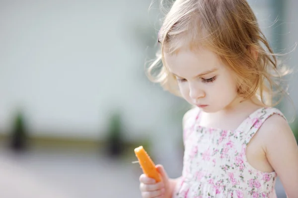 Adorabile bambino in età prescolare ragazza mangiare carota — Foto Stock