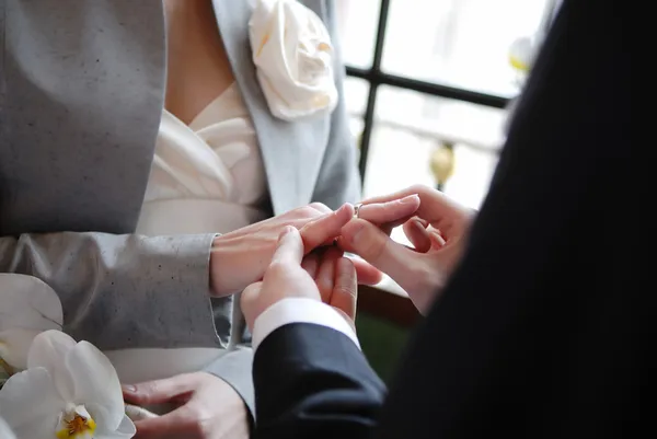 Brudgummen sätter en ring på brudens finger — Stockfoto