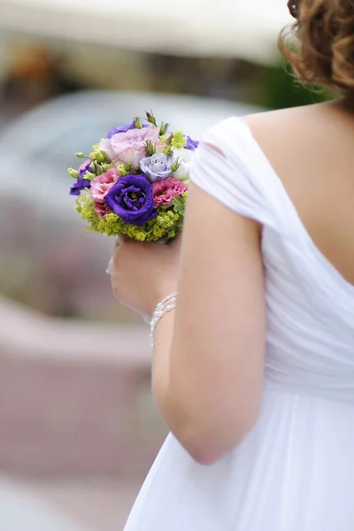 Bride holding blue flowers — Stock Photo, Image