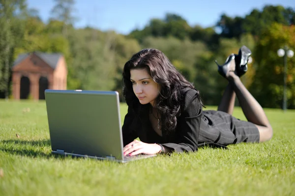 Giovane signora con un quaderno in un parco — Foto Stock