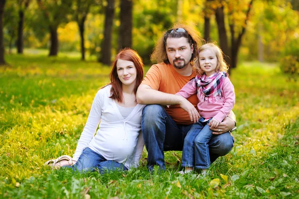 Beautiful expecting family in autumn park — Stock Photo, Image