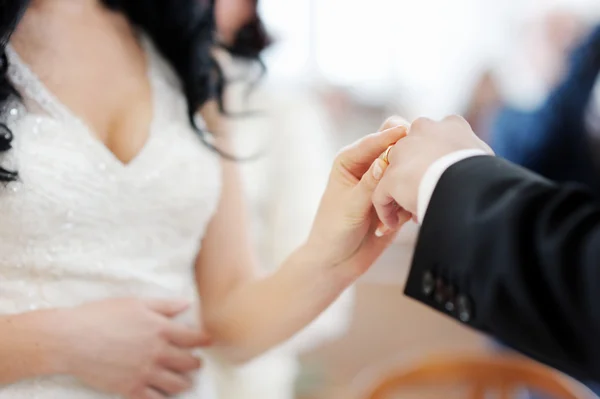 Bride putting a ring on groom's finger — Stock Photo, Image